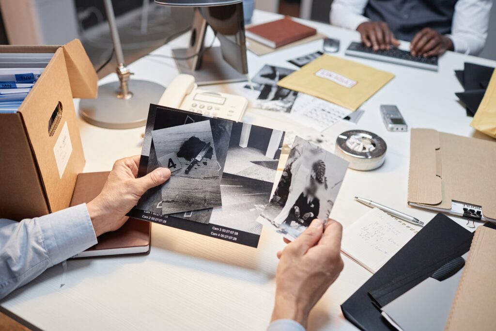 Close,up,of,male,detective,holding,photos,with,evidence,during